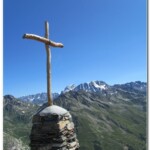 La croce in cima alla Tête de Crevacol sullo sfondo il Monte Vélan e dietro le Grand Combin